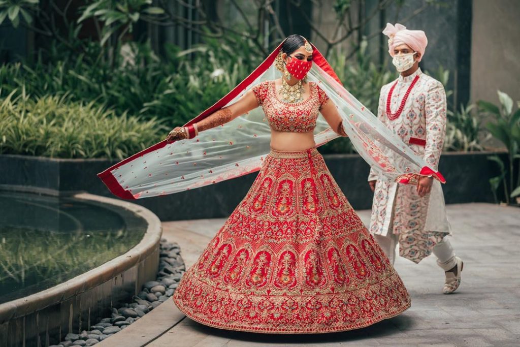 Indian bride & groom wearing color-coordinated wedding masks